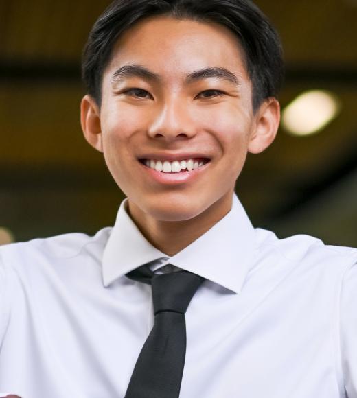 Smiling young man in white shirt and black tie, head-and-shoulders portrait