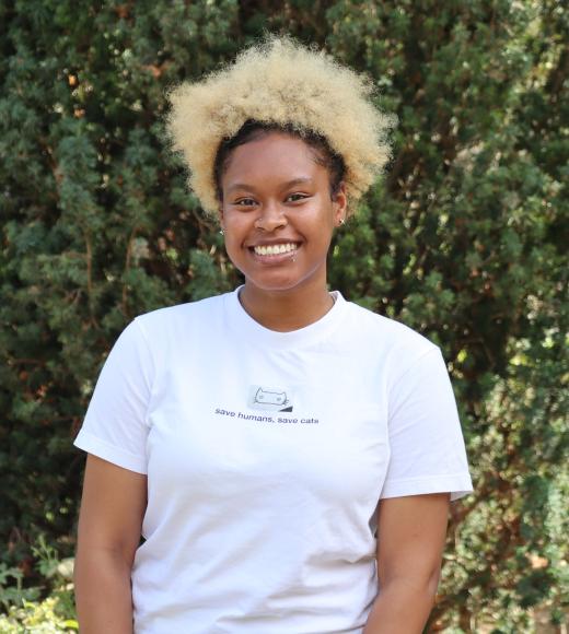 profile picture of Faapuloua standing in front of a big giant green tree and she is wearing a white shirt