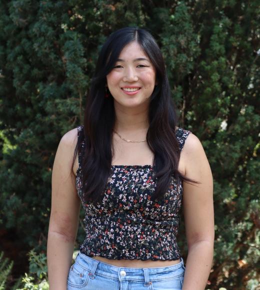 profile picture of Shannon standing in front of a giant tree and she is wearing a black blouse and blue jeans