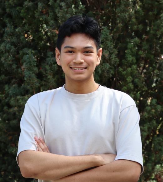 profile photo of Will standing in front of a tall green tree and he is wearing a while shirt